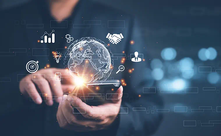 A business person clicking on their phone and icons of a world and network connections float over it.