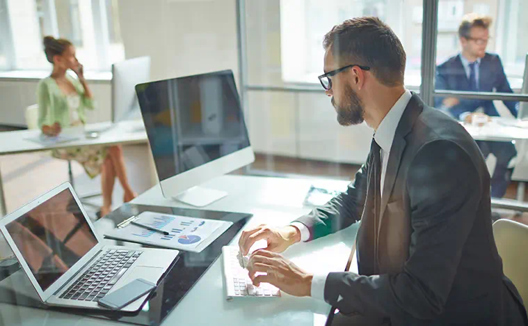 A business man works at his desk on his laptop.
